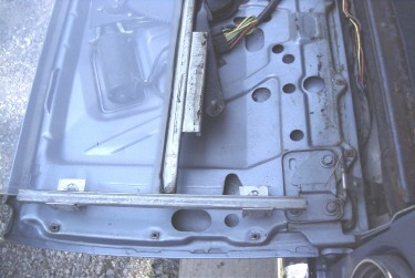 Tailgate with inner skin removed, showing right lift guide roller popped off the lift arm.